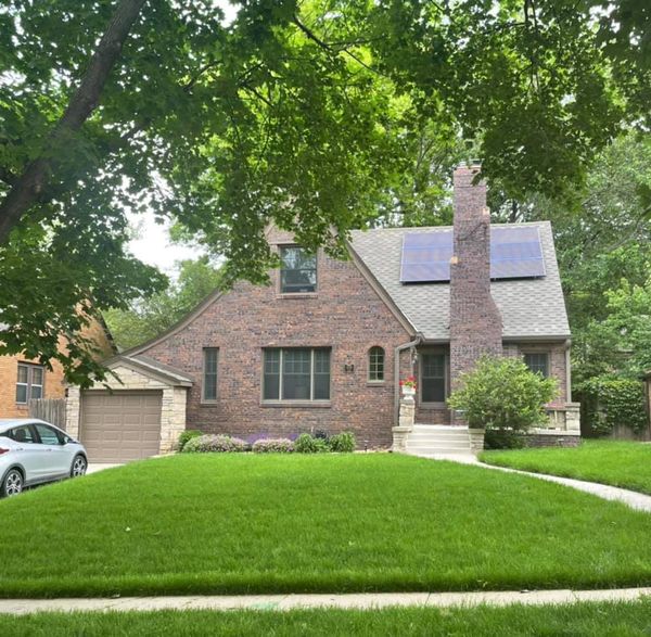 Brick Tudor showing solar panel array and roof detail — side angle