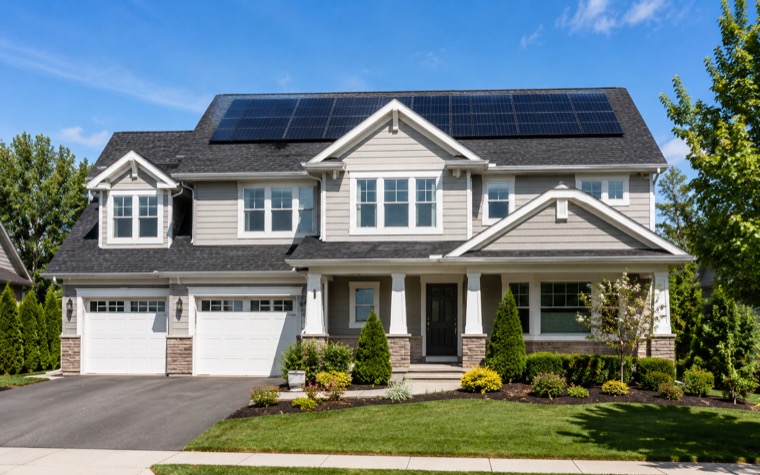 Suburban home with a fresh roof and solar panels in bright daylight